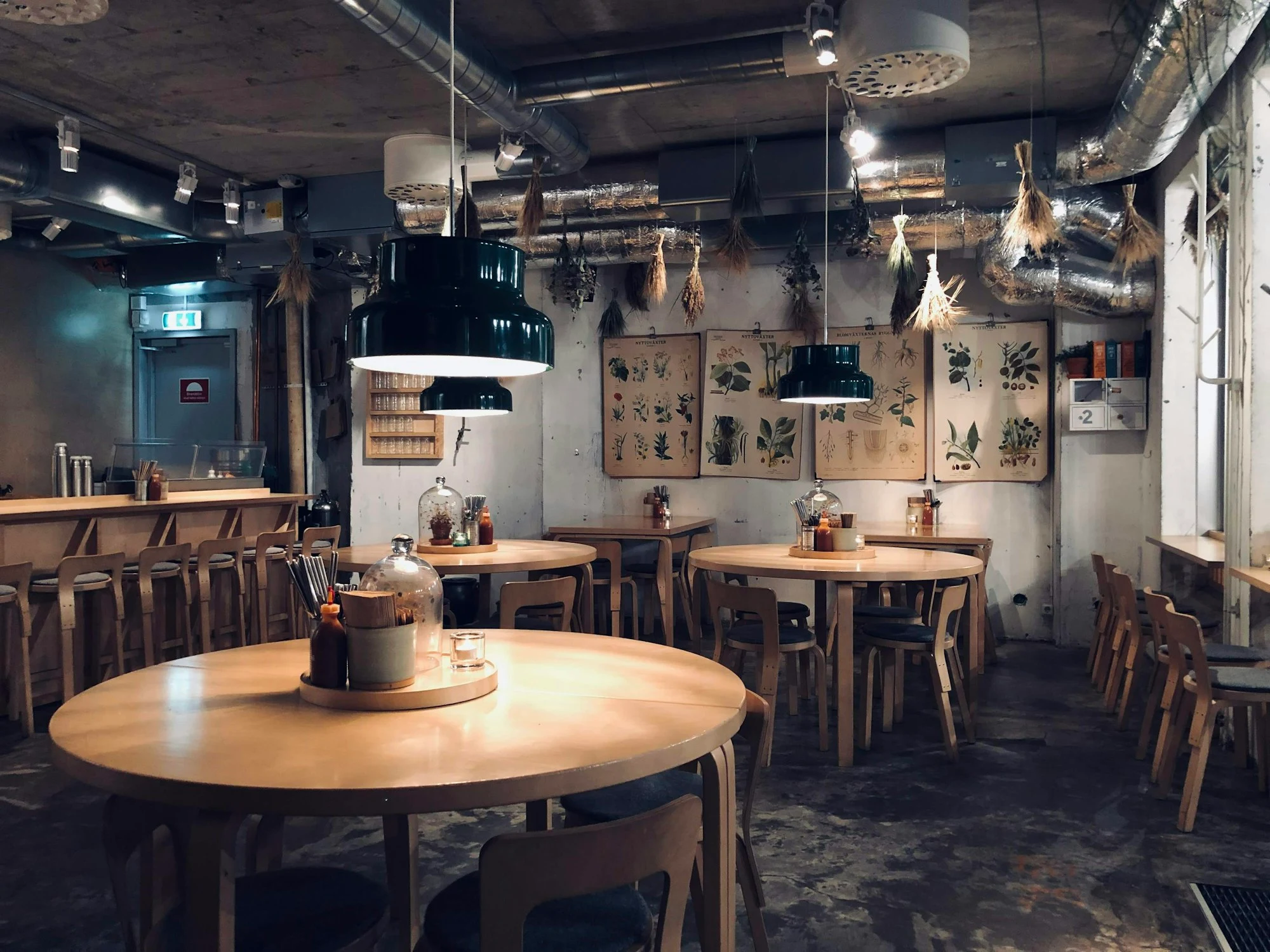 Зал FlatCoffee: круглые деревянные столы под тёплыми лампами